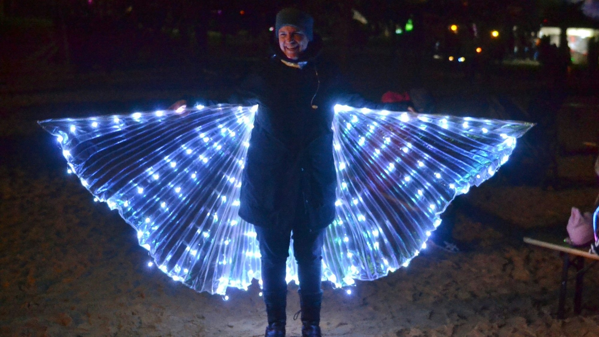 Das Bild zeigt Besucherin Anja, die ihre beleuchteten Flügel spannte.