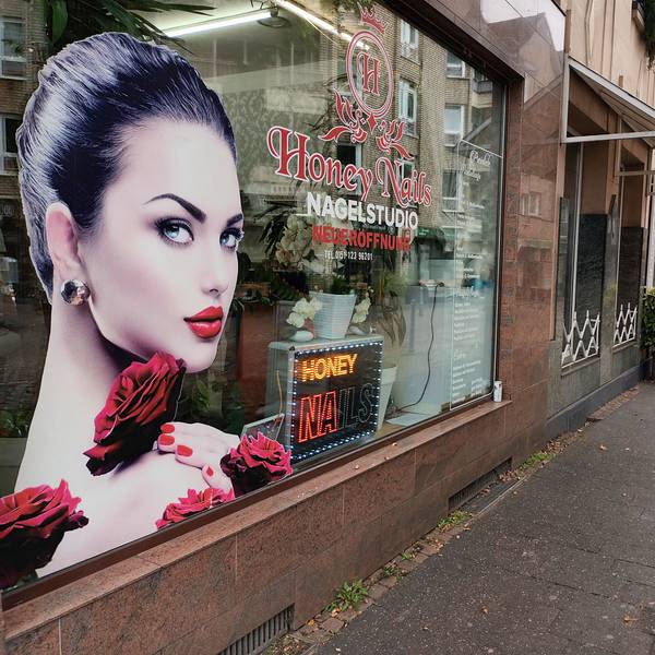Ein Schaufenster eines Nagelstudios neben einem alteingesessenen Polstereibetrieb