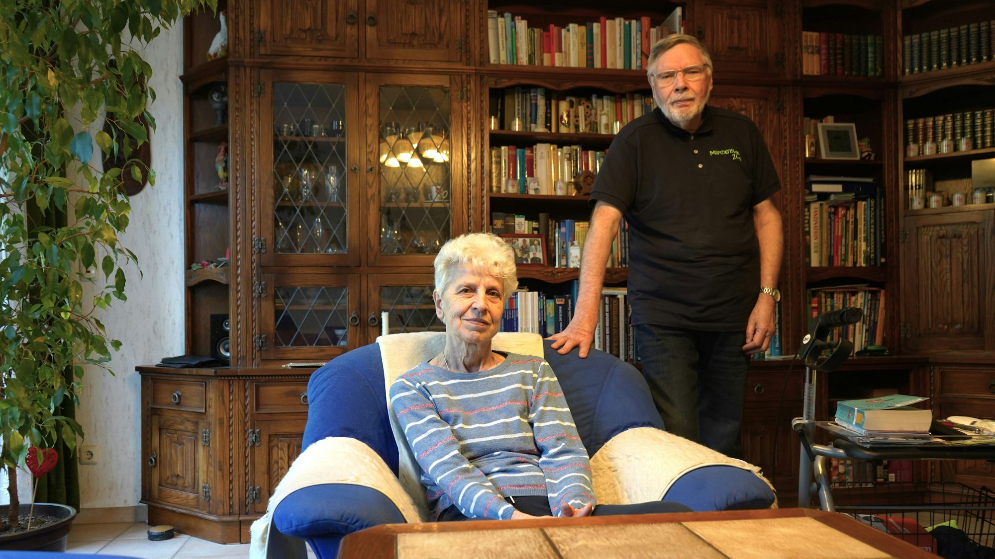 Das Foto zeigt zwei Senioren vor einer Bücherwand.