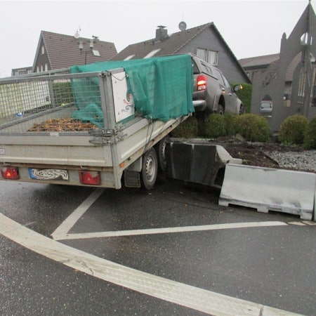 Ein Auto mit Anhänger steht am Montag (28.10.) im Hochbeet des Kreisverkehrs in Odenthal-Blecher.