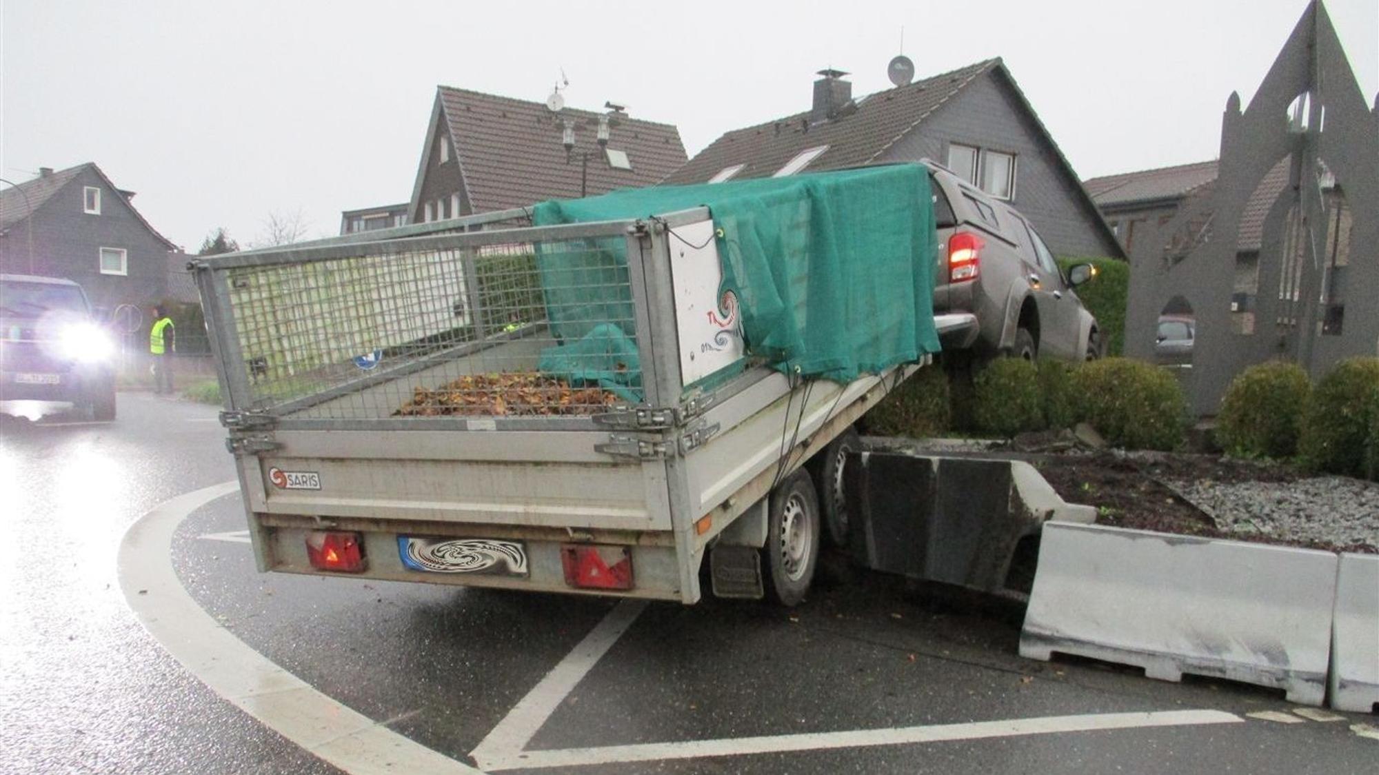 Ein Auto mit Anhänger steht am Montag (28.10.) im Hochbeet des Kreisverkehrs in Odenthal-Blecher.