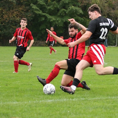 Das Bild zeigt einen Zweikampf zwischen zwei Fußballern.