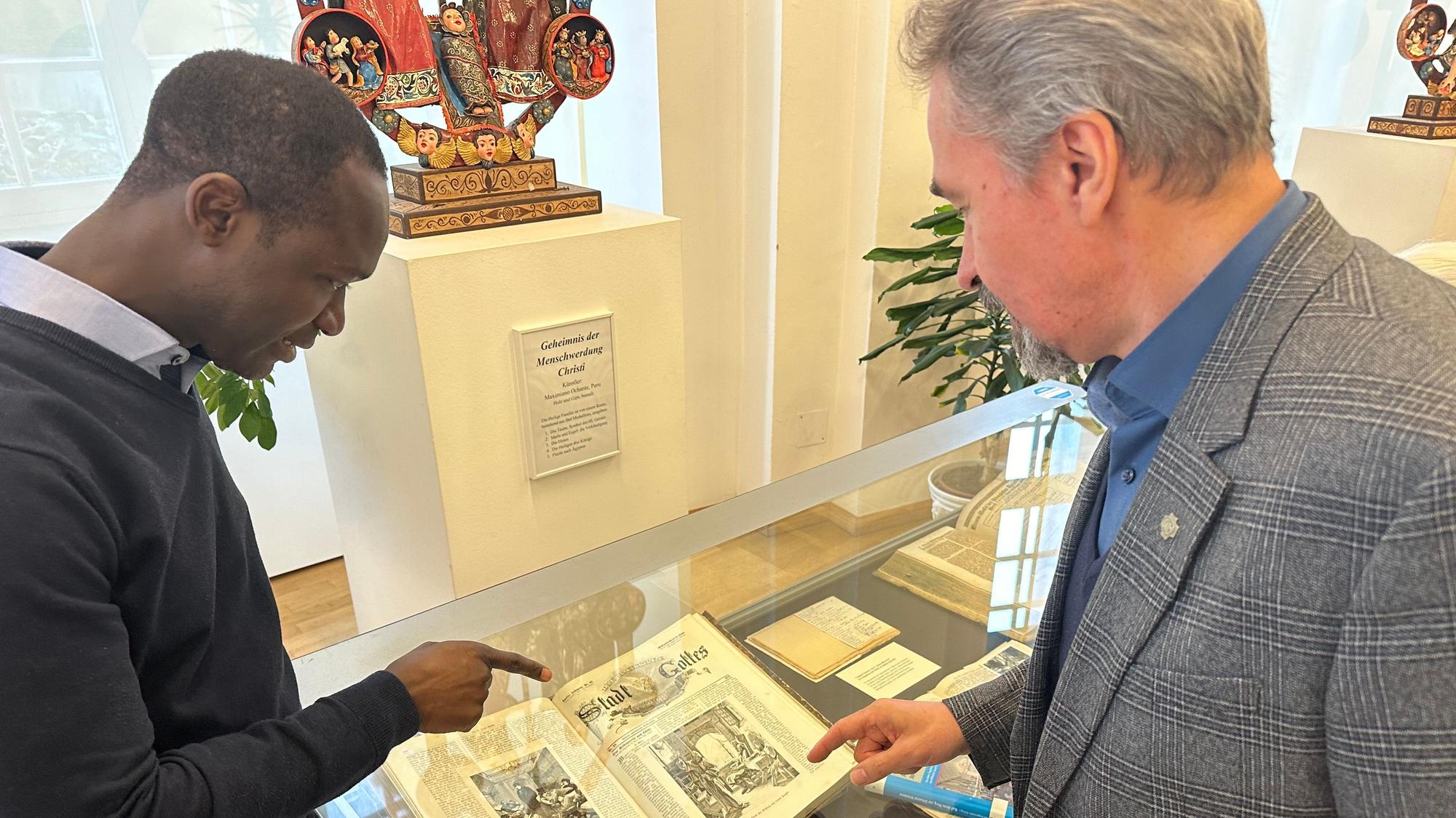 Die Steyler Missionare zeigen Schätze ihrer Bibliothek, Provinzial Pater Peter Claver Narh (l.) und Stanislaw Grodz (r.), Dirketor des Anthropos-Institutes der Steyler, an einer Vitrine