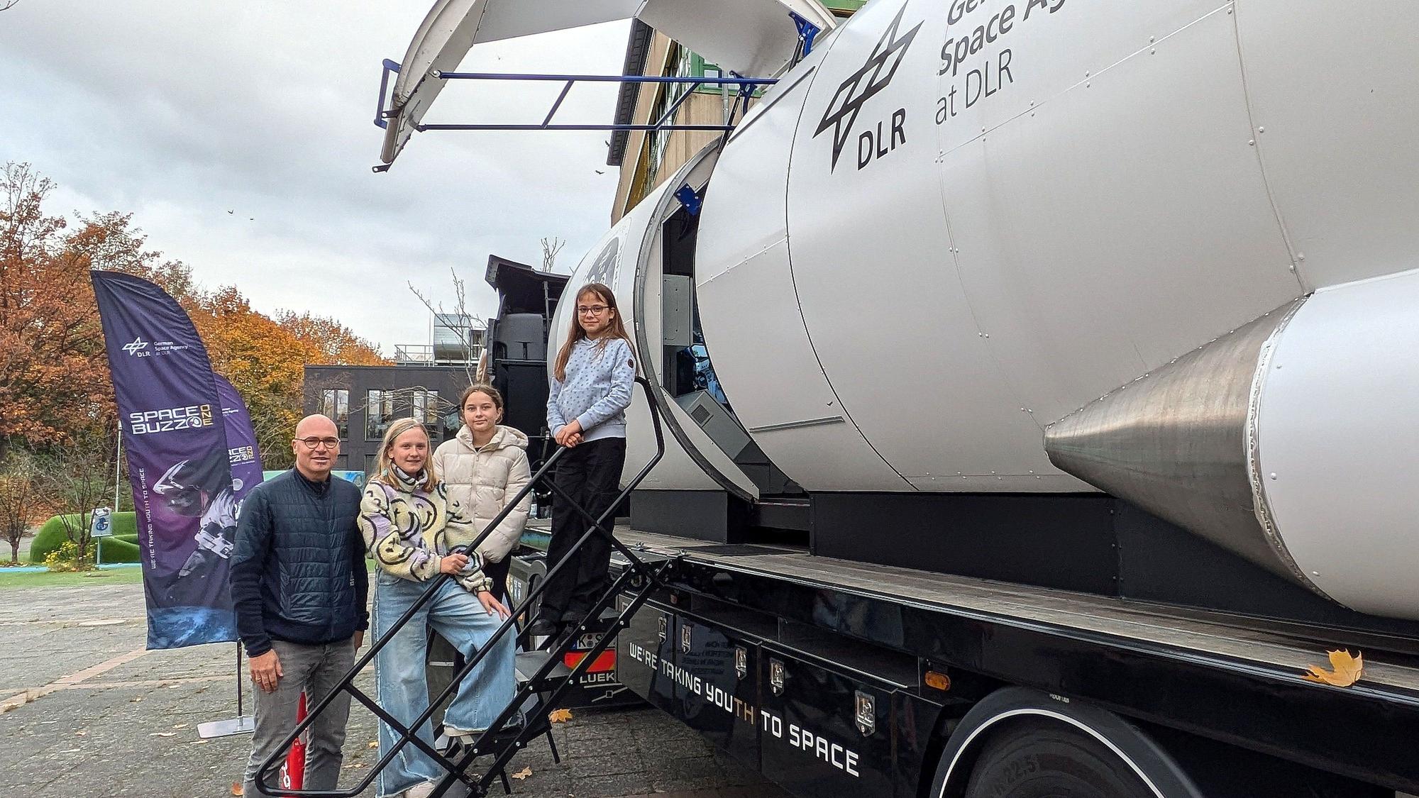 MINT-Koordinator Achim Kittelmann steht mit Schülerinnen an der Rakete.