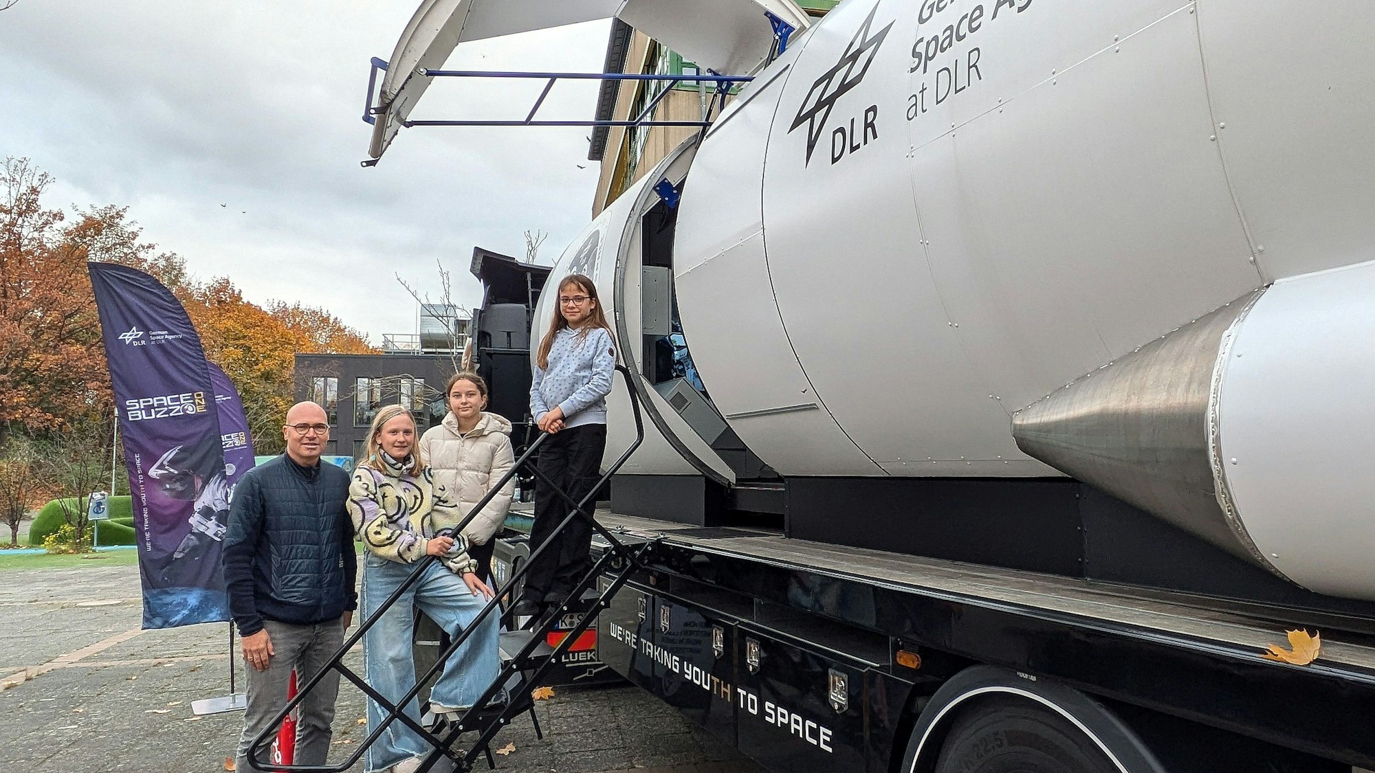 MINT-Koordinator Achim Kittelmann steht mit Schülerinnen an der Rakete.