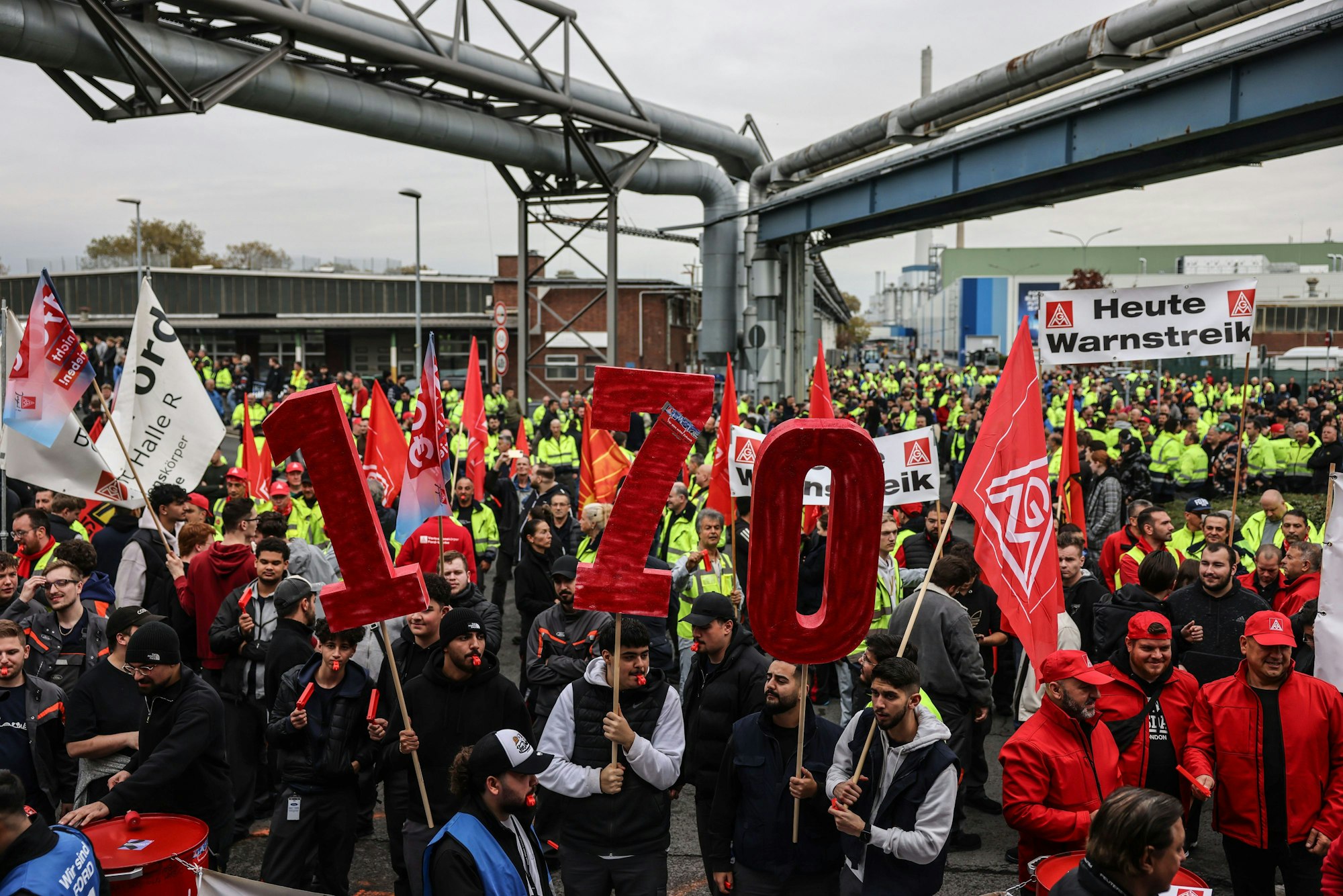Köln: Beschäftigte des Automobilherstellers Ford stehen im Rahmen eines Warnstreiks auf dem Werksgelände zusammen.