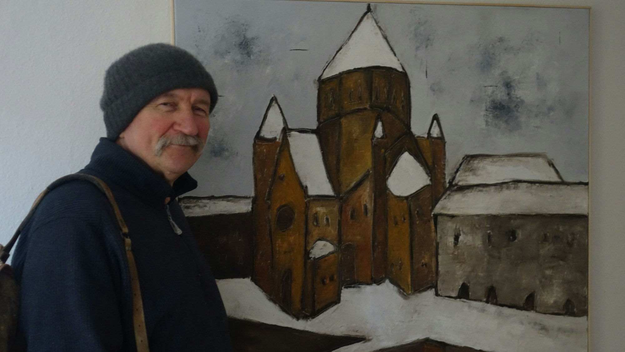 Ein Mann vor einem Gemälde einer Synagoge