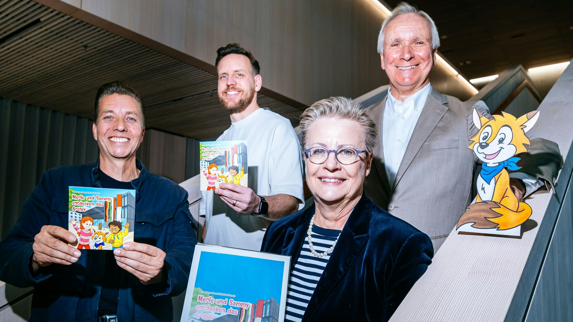 Freuen sich über das neue Buch: Illustrator Heiko Wrusch (v.l.n.r.), Autor Mirko Born-Nanni, Archivdirektorin Bettina Schmidt-Czaia und Burkhard von der Mühlen, Vorstandsvorsitzender des Fördervereins.