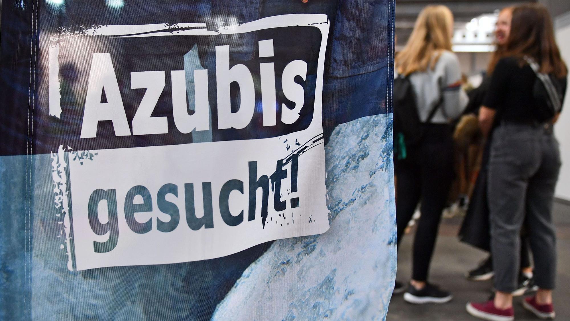 Auf einem Banner bei einer Berufsorientierungsmesse steht „Azubis gesucht“.