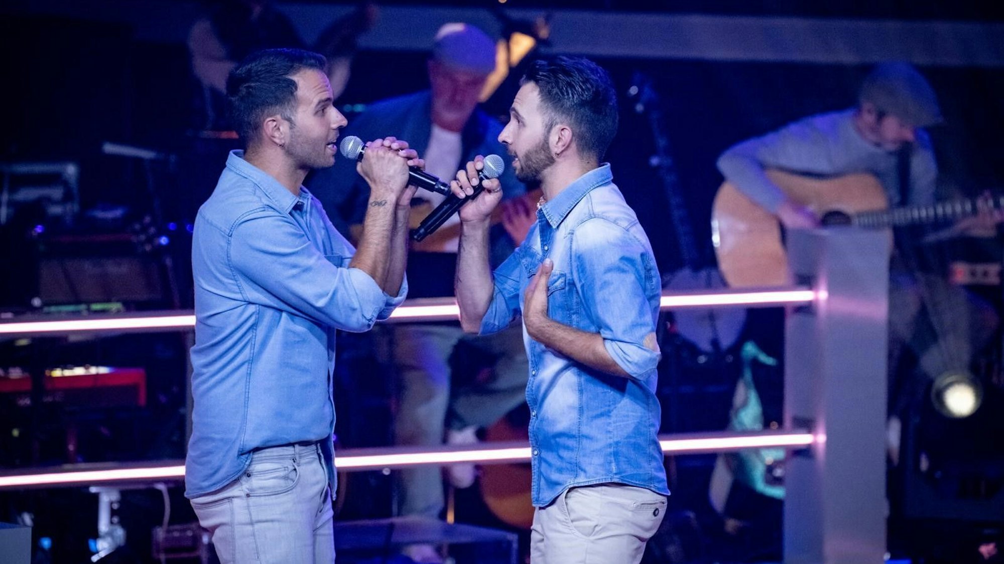 Zwei Brüder singen auf einer Bühne.