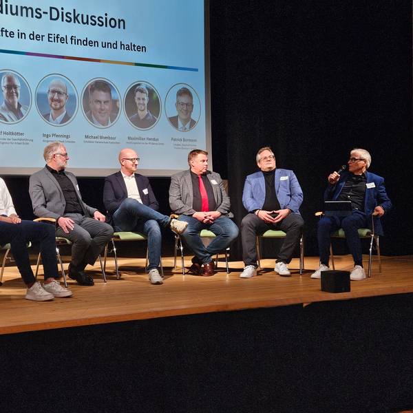 Die Teilnehmer einer Podiumsdiskussion der DLG Eifel sitzen auf der Bühne des Gemünder Kurhauses.