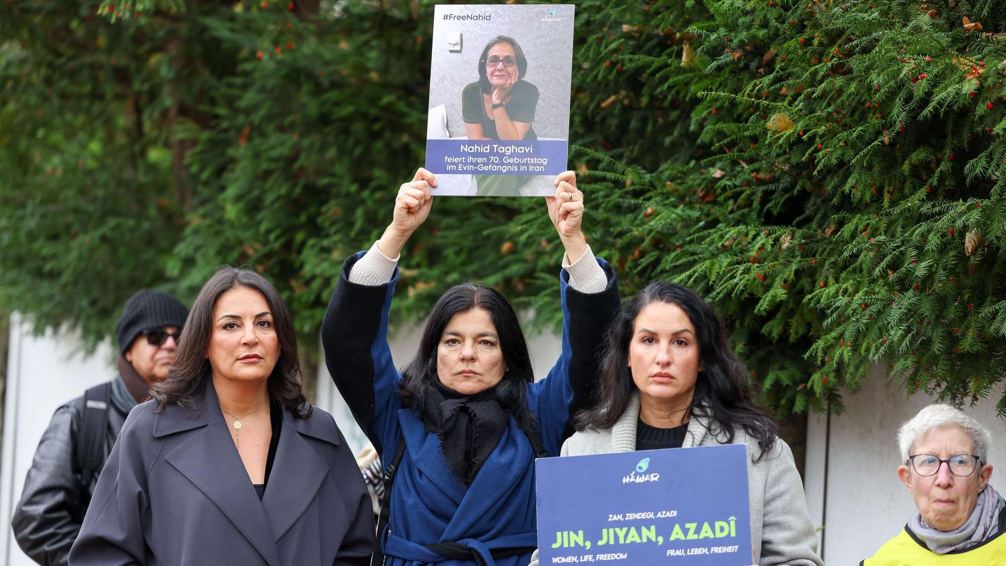 29.10.2024, Berlin: Düzen Tekkal, Jasmin Tabatabai und Minu Barati-Fischer stehen mit Plakaten vor der Botschaft der Islamischen Republik Iran nach der Hinrichtung des Deutsch-Iraners Djamshid Sharmahd.