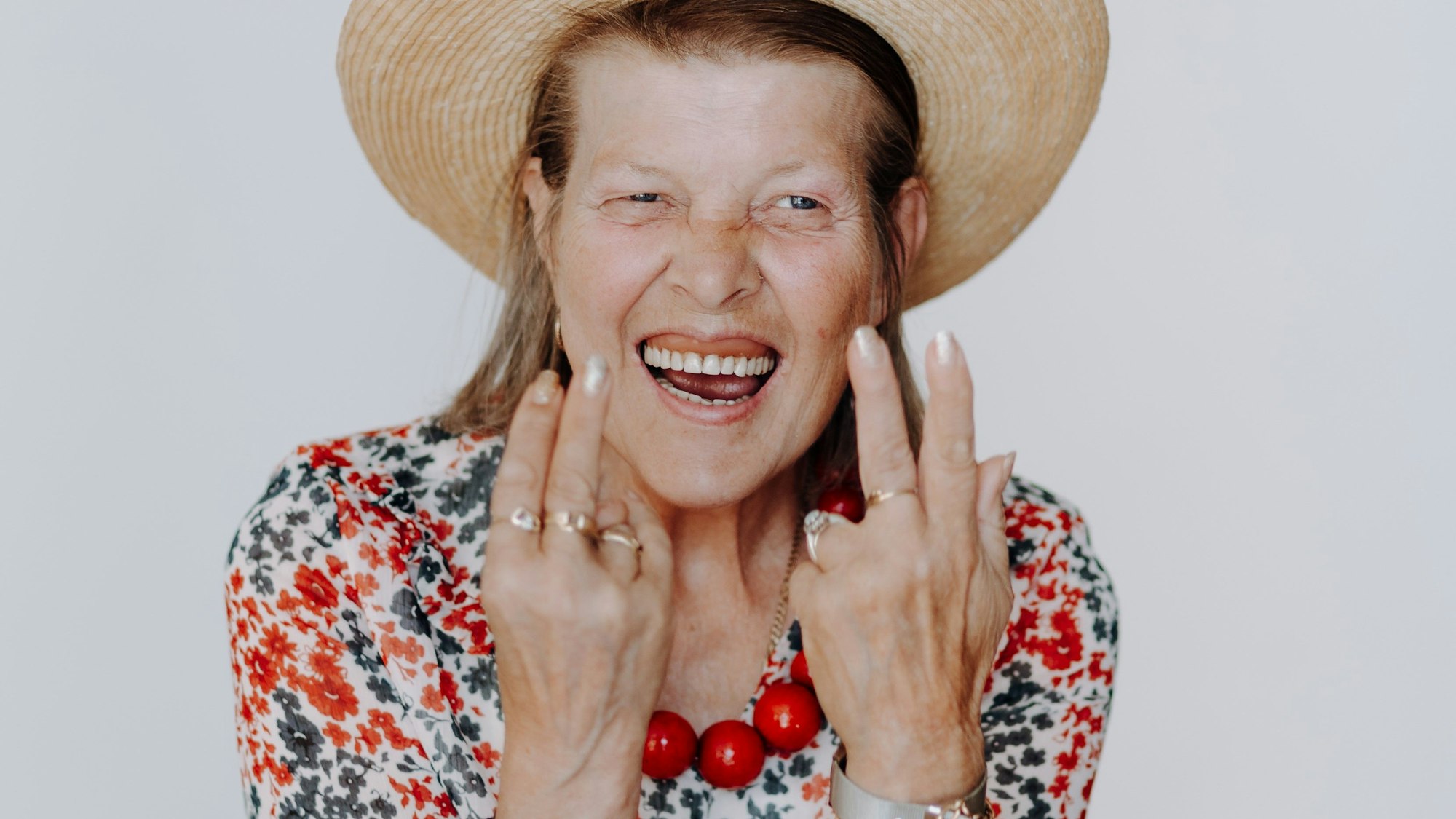 Das Porträt einer älteren Heimbewohnerin zeigt eine lebensfrohe Frau.