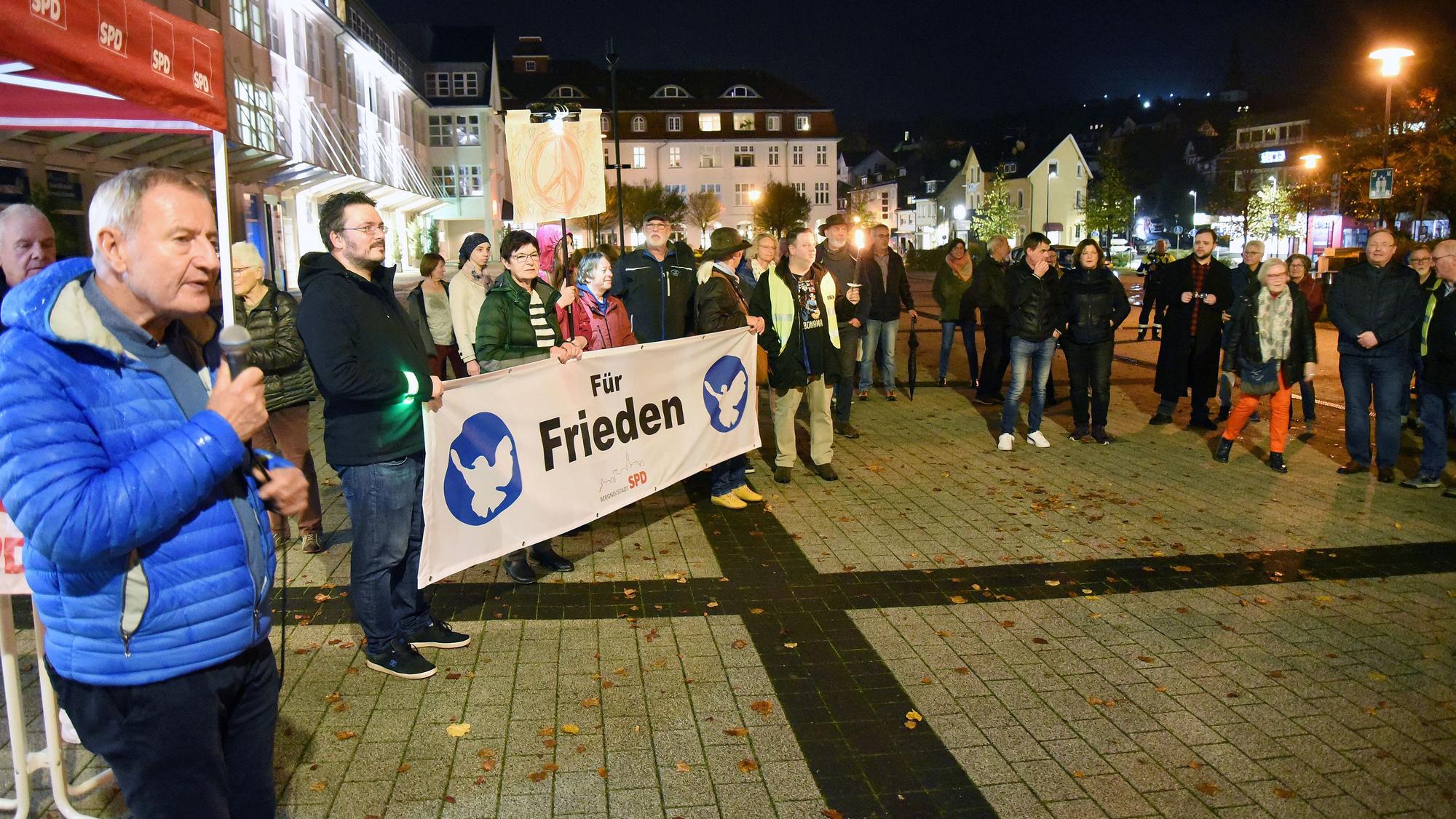 Ein Mann spricht bei einer Friendskundgebung in ein Mikrofon.