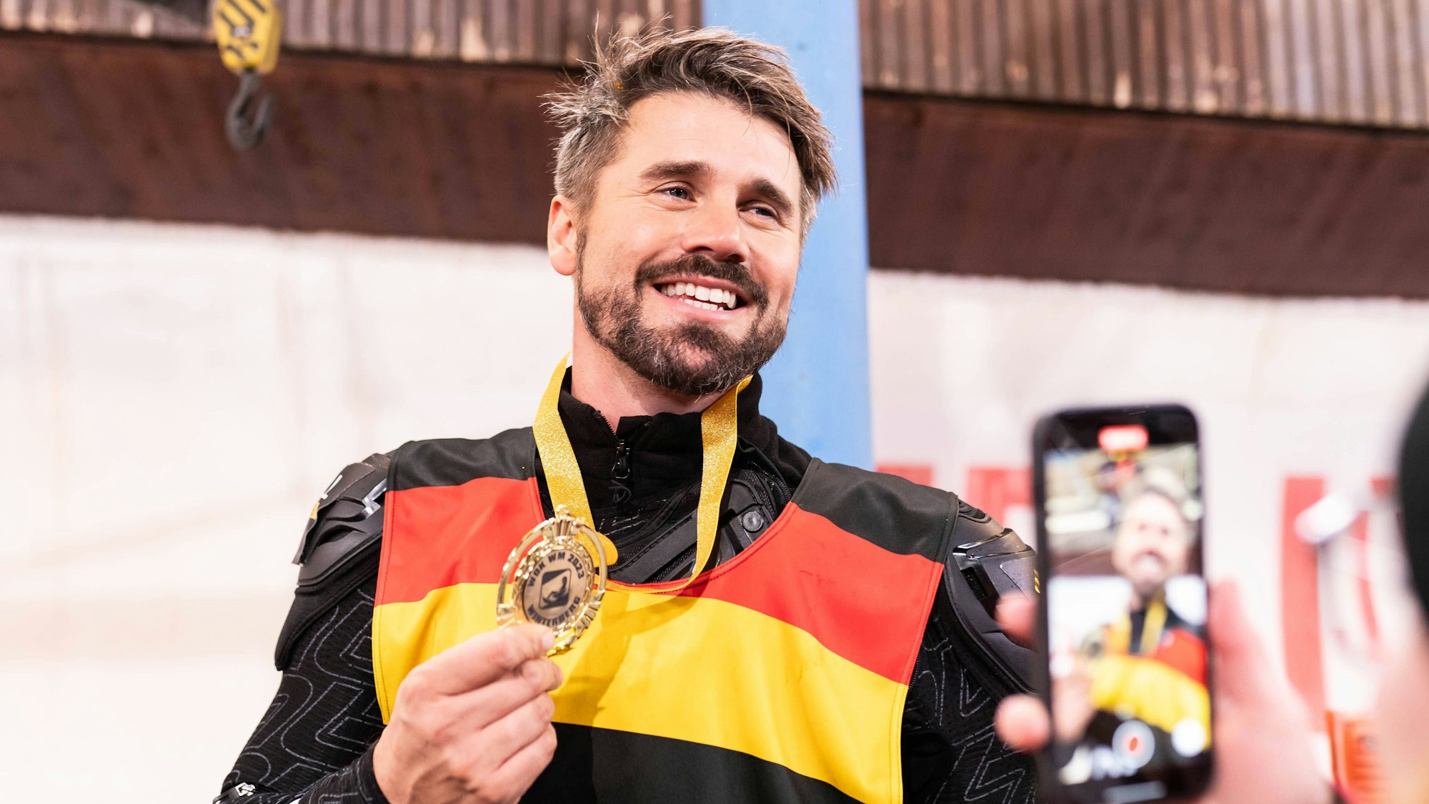 Thore Schölermann posiert mit einer Goldmedaille.