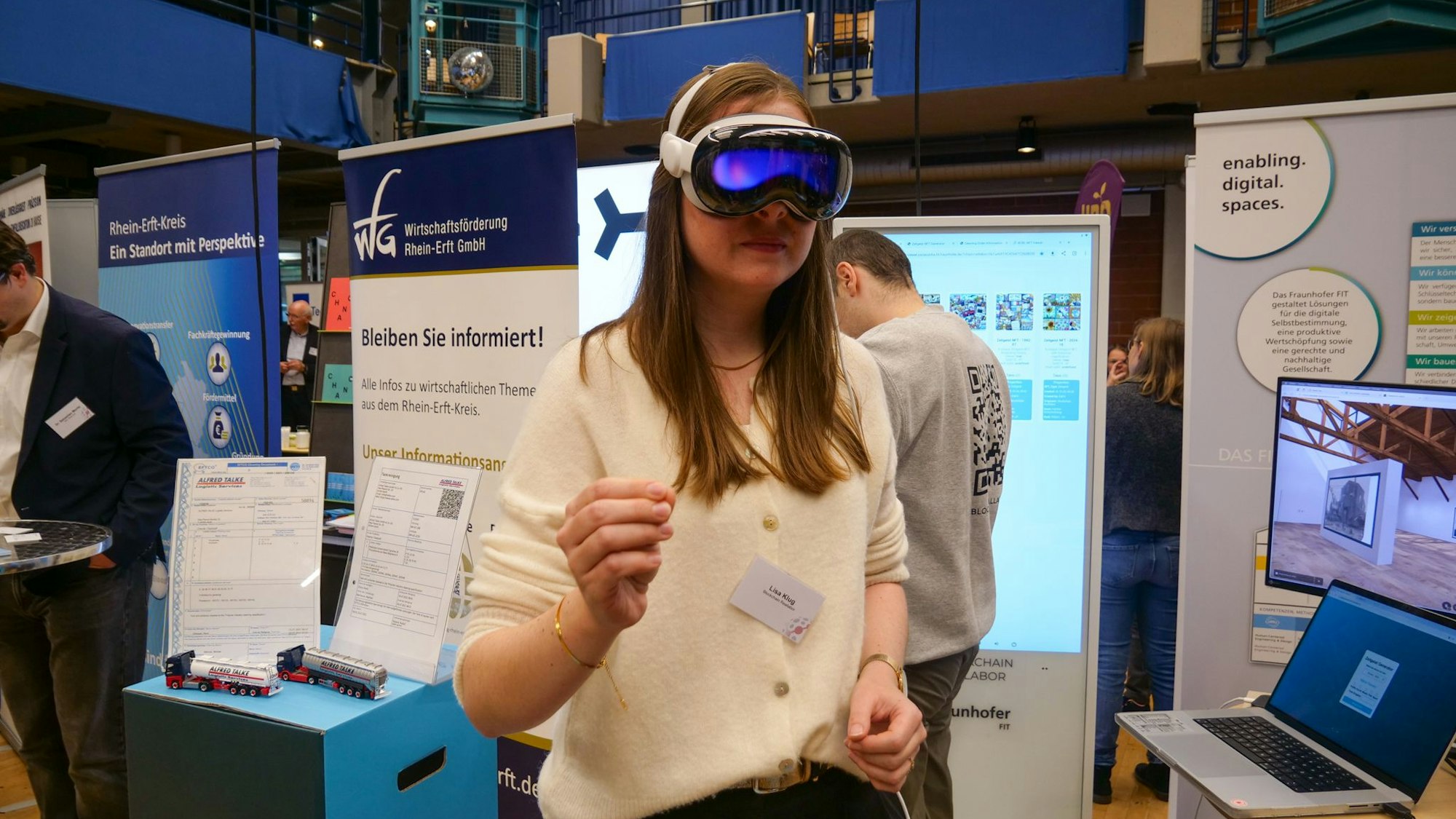 Das Foto zeigt eine Frau an einem Stand beim Wirtschaftstag, die eine VR-Brille trägt.