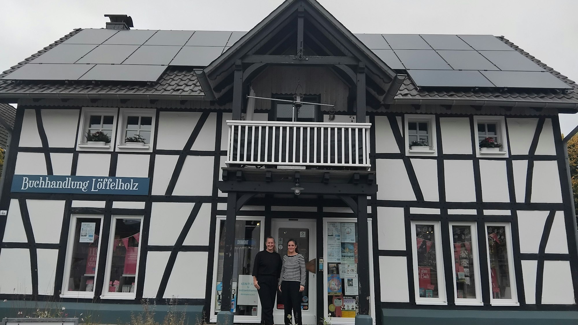 Zwei Frauen stehen im Eingang eines Fachwerkhauses.