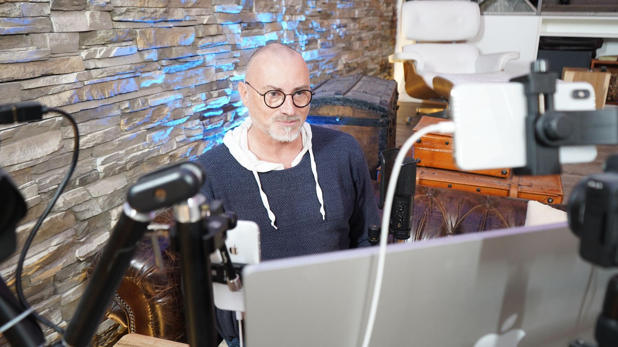 Das Foto zeigt einen Mann hinter einem PC.