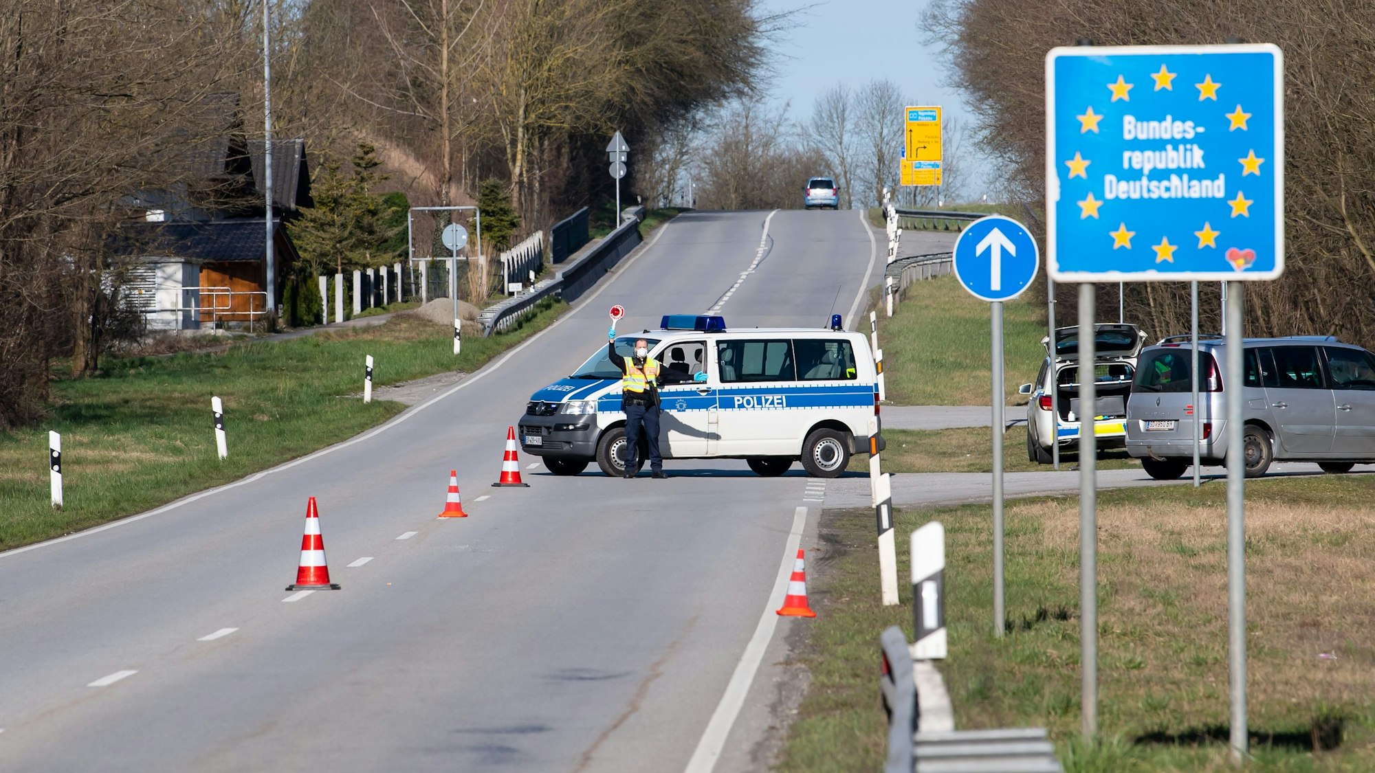 Polizisten stehen an der Bundesstraße 512 in der Nähe von Neuhaus am Inn an einer Kontrollstelle an der Grenze zu Österreich.