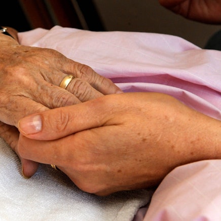 Die Hand einer Frau hält die einer anderen (Symbolfoto).