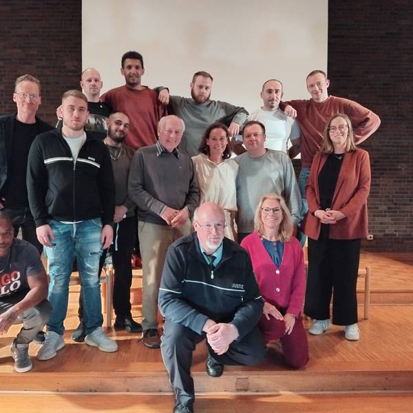 15 Leute verschiedenen Alters stehen für ein Gruppenfoto zusammen.