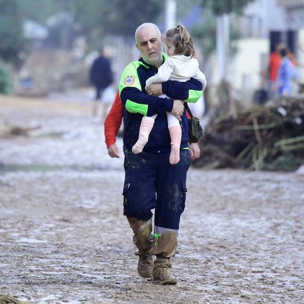 In Paiporta bei Valencia trägt ein Helfer ein Kind aus einem von der Flut zerstörten Bereich.
