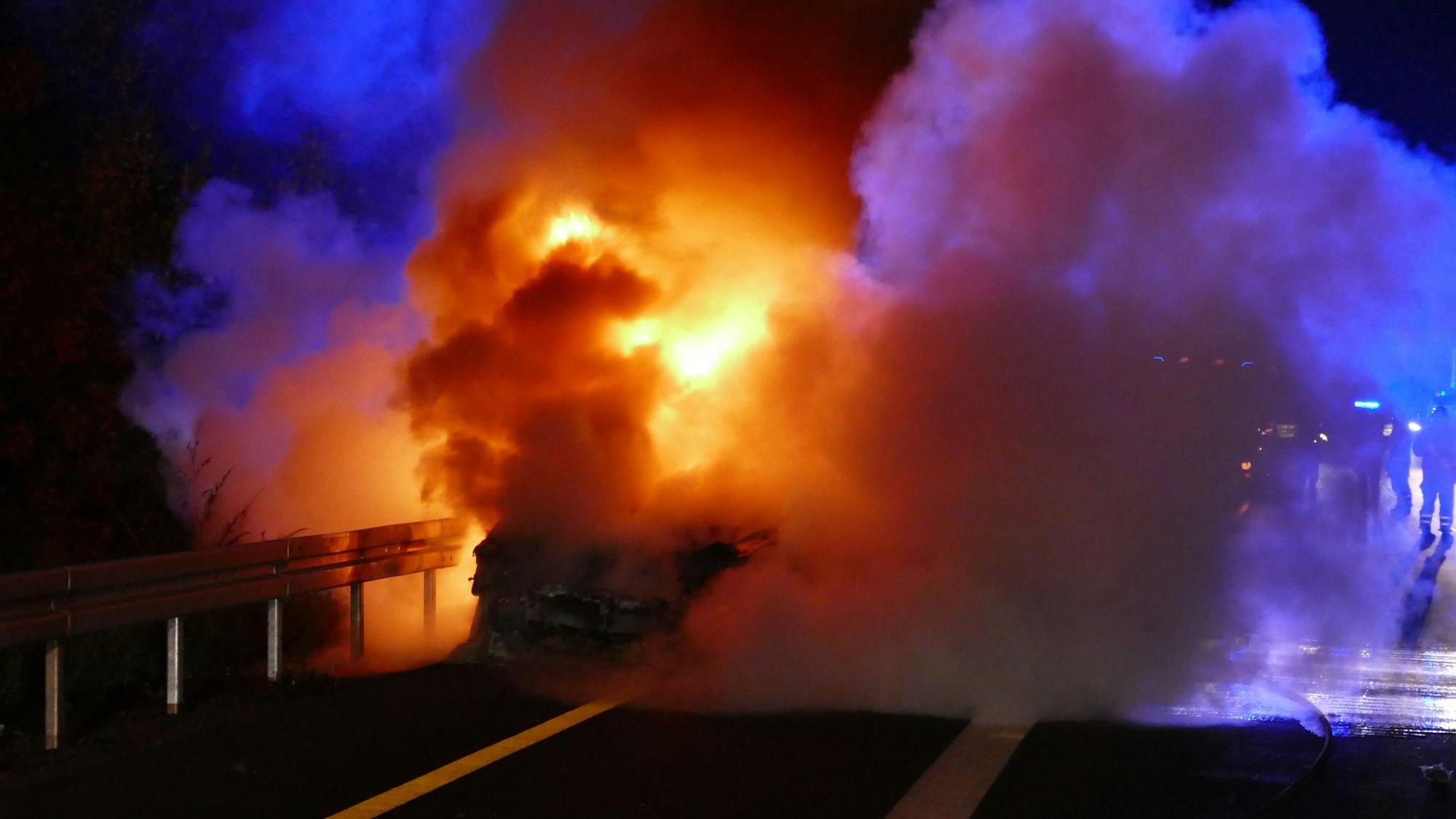 Ein brennendes Auto in der Dunkelheit.