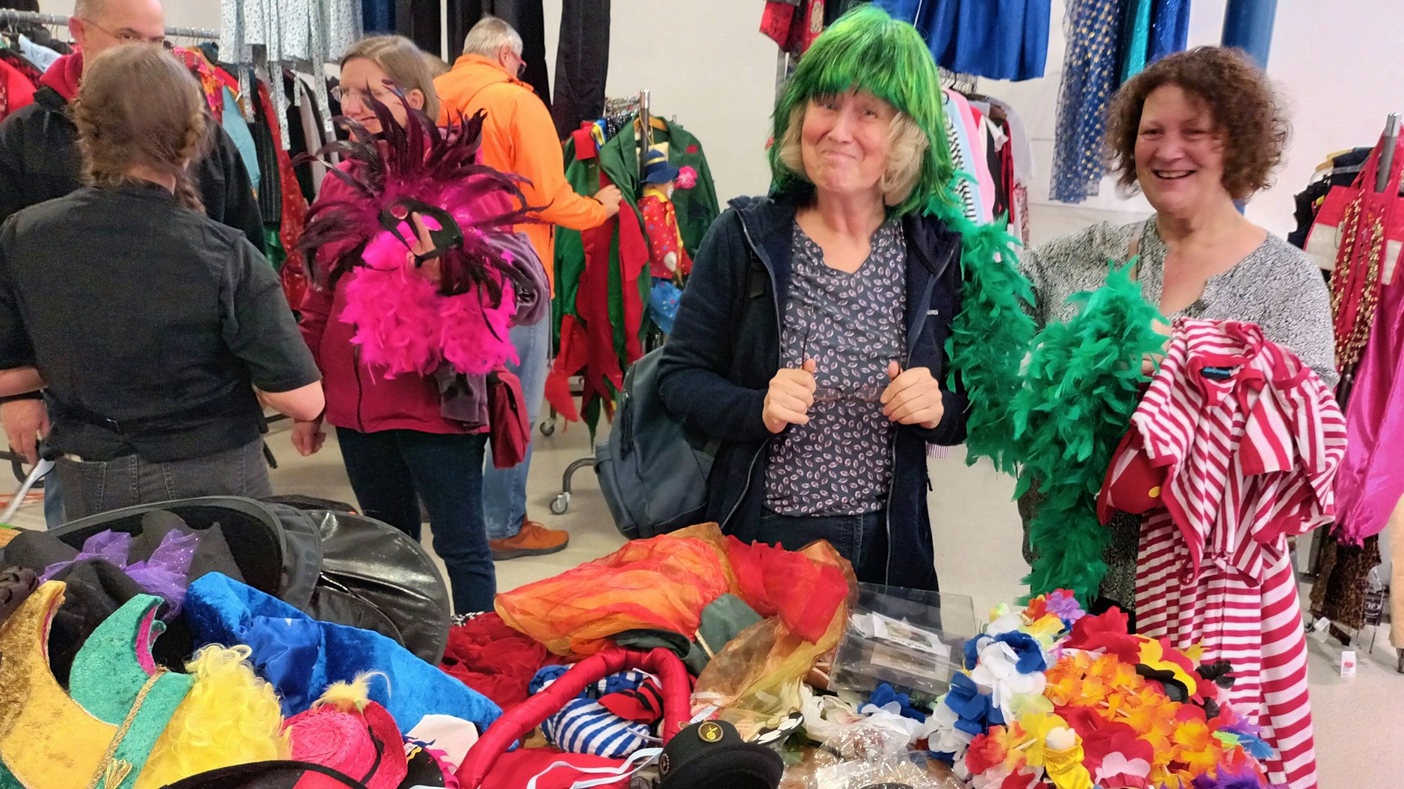 Zwei Frauen vor einem Tisch mit Karnevals-Accessoires