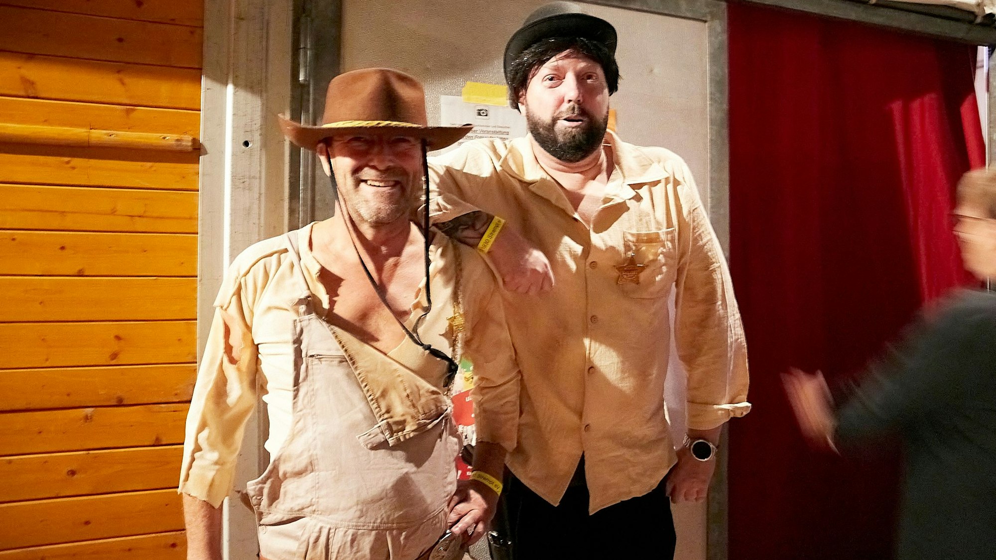 Zwei Männer im Bud Spencer und Terence Hill Kostümen stehen vor einer Tür.
