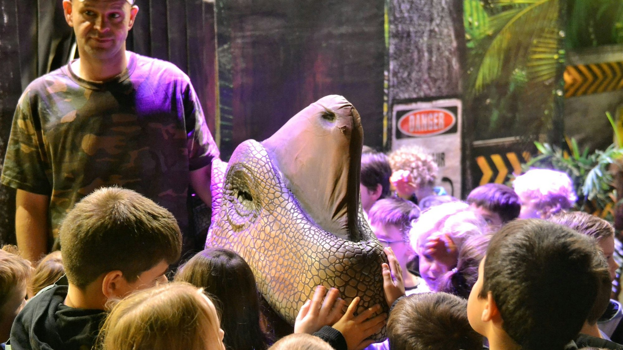 Kinder fassen eine Dino-Attrappe an.