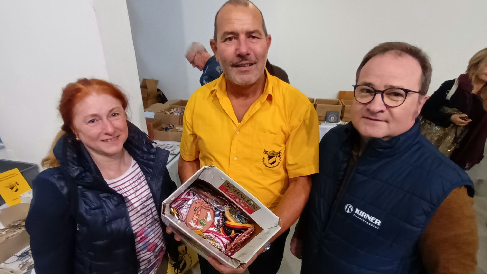 Ehrengarde Siegburg Karnevalsbasar Rundschau Altenhilfe DIE GUTE TAT
Ehrengard-Vorsitzener Farid Wagner nimmt eine ganze Kisten Orden von Alexandra und Frank Stock entgegen.