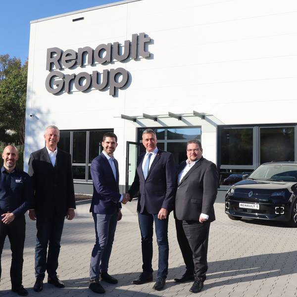 Das Foto zeigt fünf Männer in Anzeigen vor dem neuen Schulungszentrum der Renault Group. Im Hintergrund ein Auto.