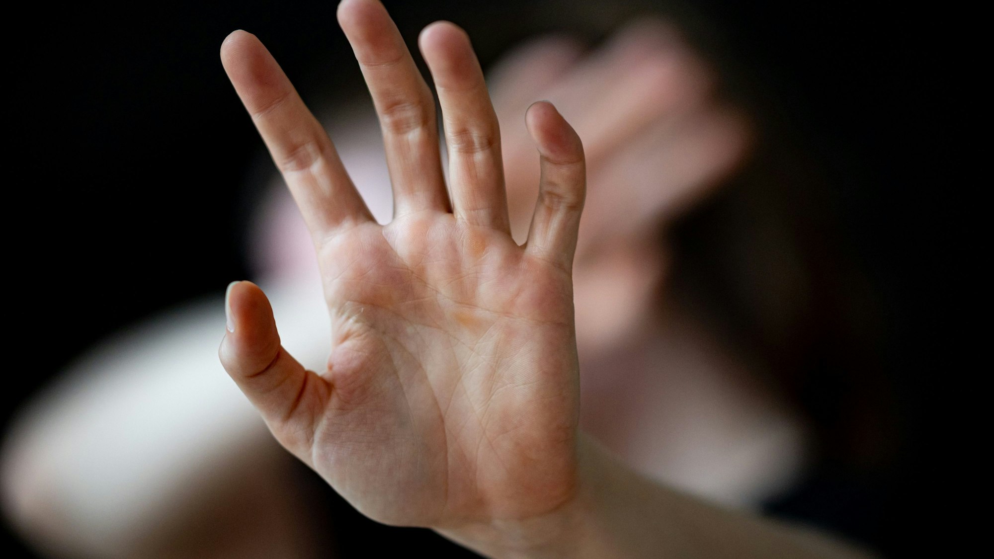 Eine Frau hält ihre Hände vor das Gesicht.