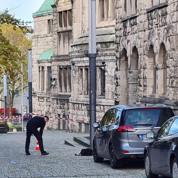 Einsatzkräfte stehen am Rabbinerhaus bei der Alten Synagoge.