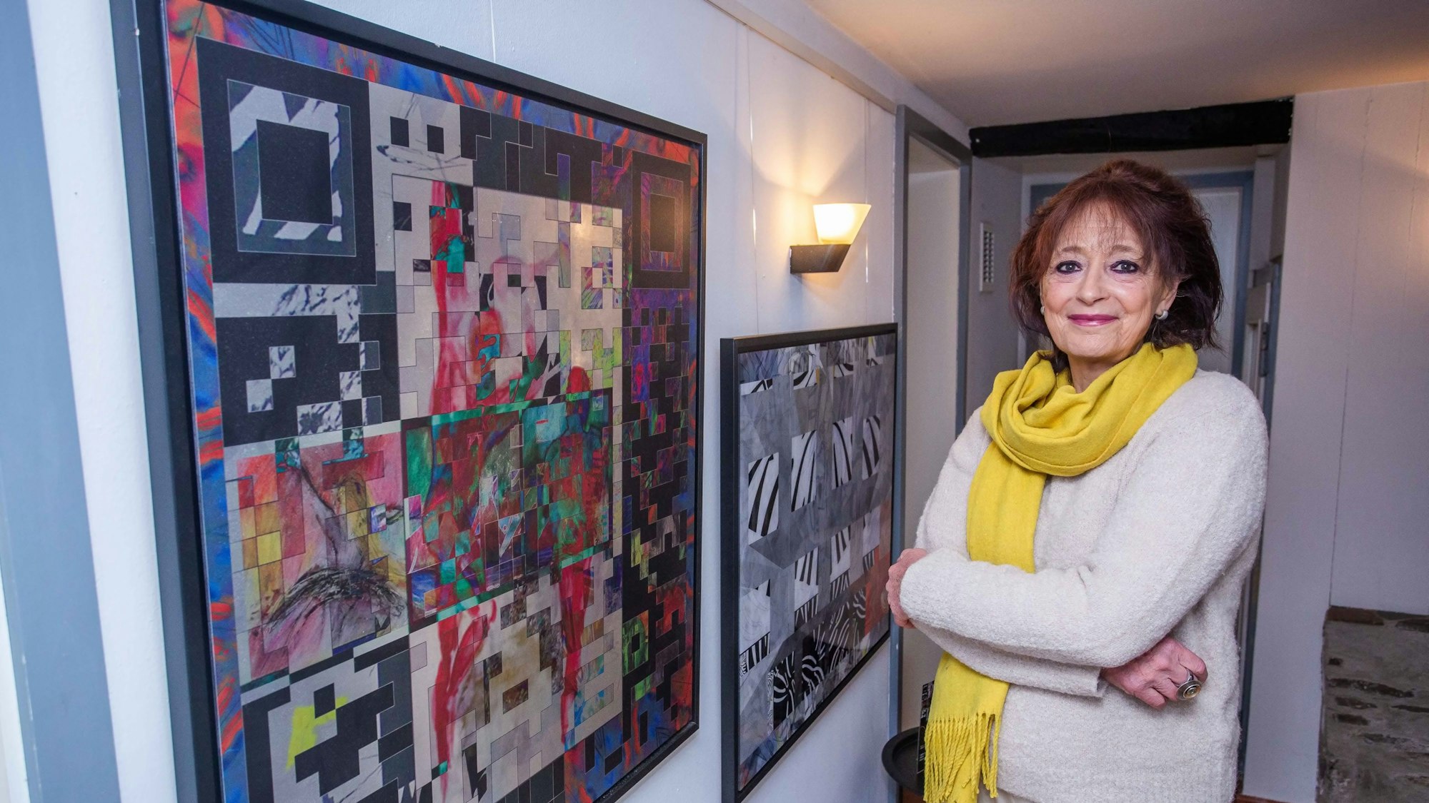 Eine Künstlerin präsentiert in ihrem Atelier ihre Bilder.