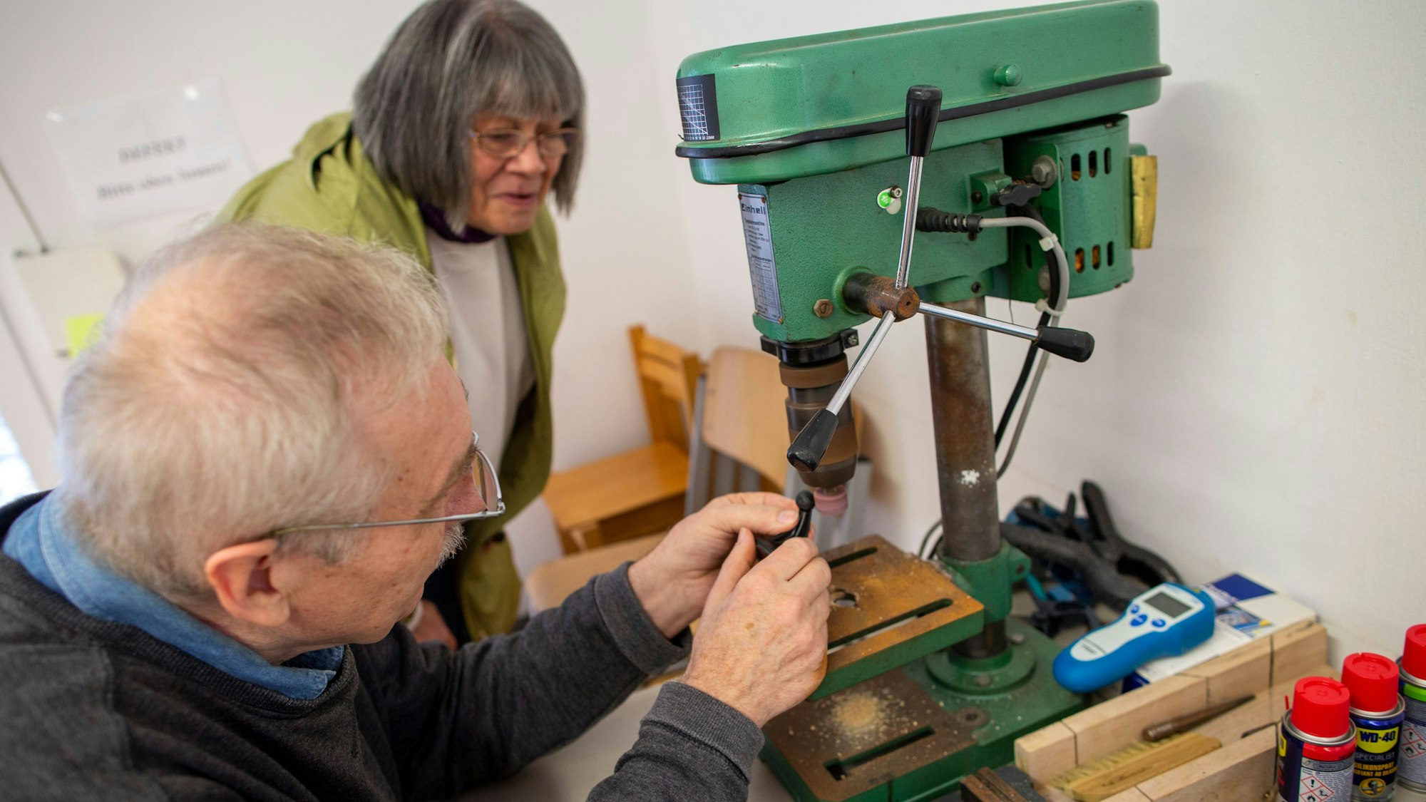 Ein Mann schleift eine Navi-Halterung an einer Schleifmaschine ab.