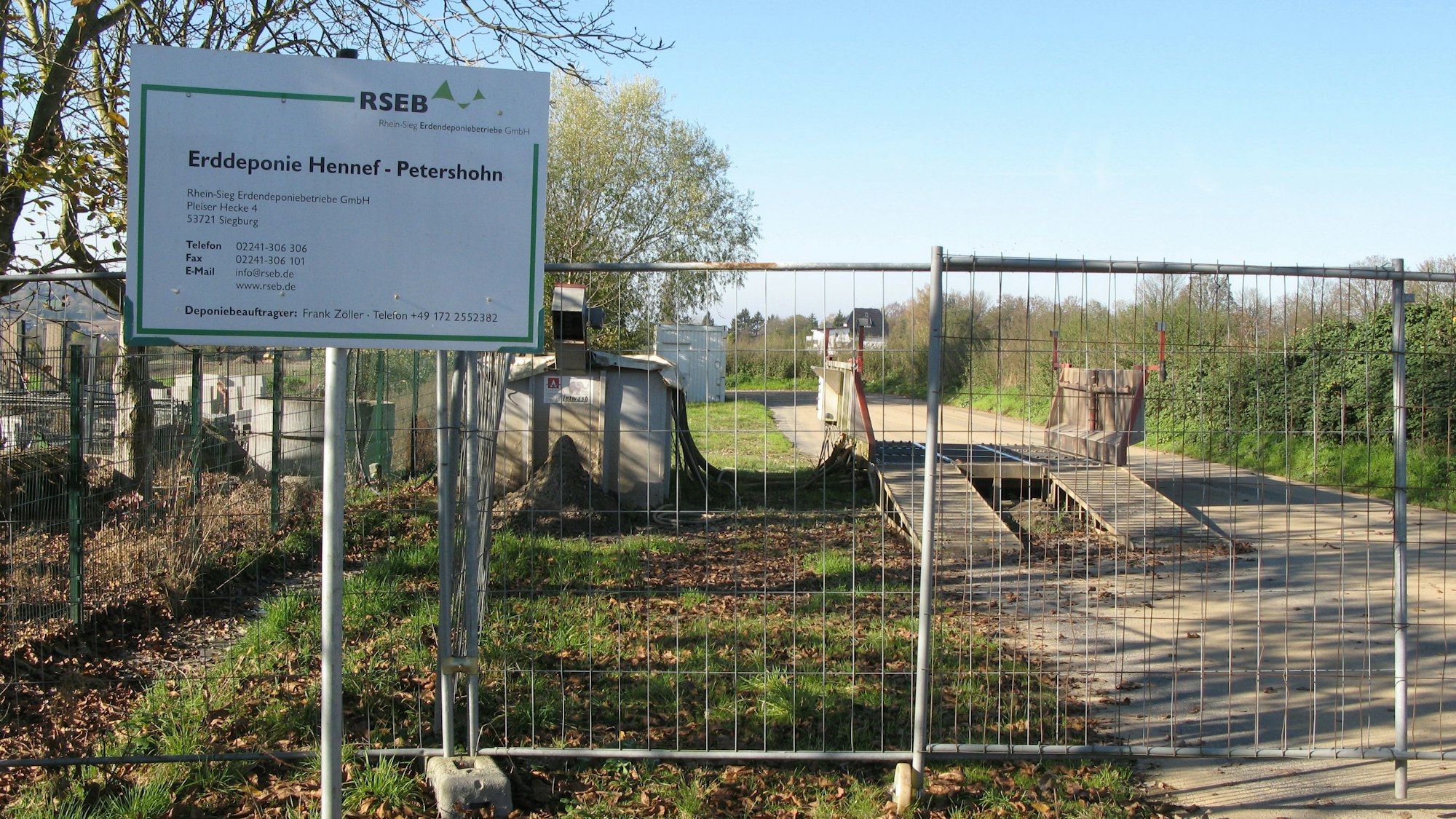 Die Zufahrt zur Erddeponie in Hennef-Petershohn mit einem Schild ist mit einem Bauzaun versperrt.