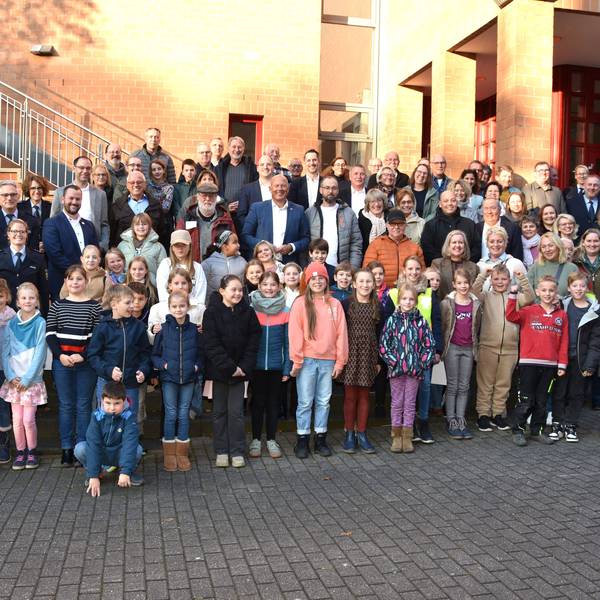 Auf dem Bild ist eine große Gruppe Kinder, Lehrer mit Vertretern der Polizei und Landrat Frank Rock zu sehen, in mehreren Reihen hintereinander stehend.