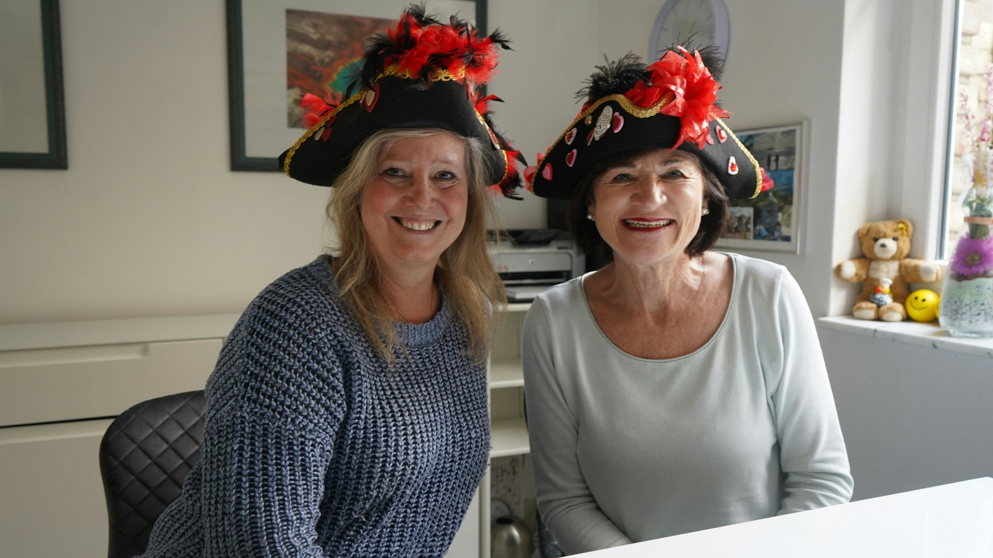 Das Foto zeigt zwei Frauen mit Karnevalshüten.