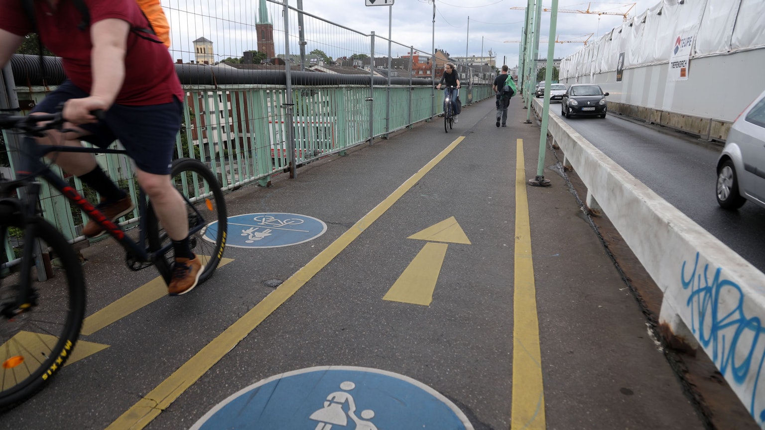 Radfahrer fahren auf einer Fahrradspur auf der Mülheimer Brücke.