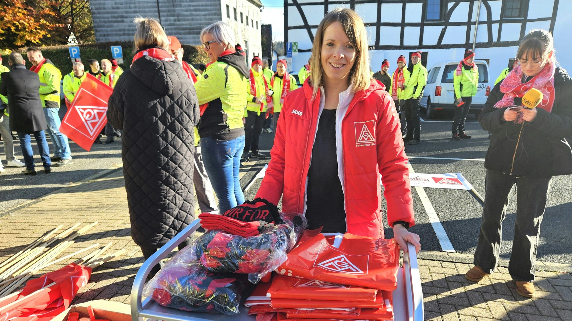 Melanie Bensberg steht vor einen Tisch mit Fahnen und Mützen..
