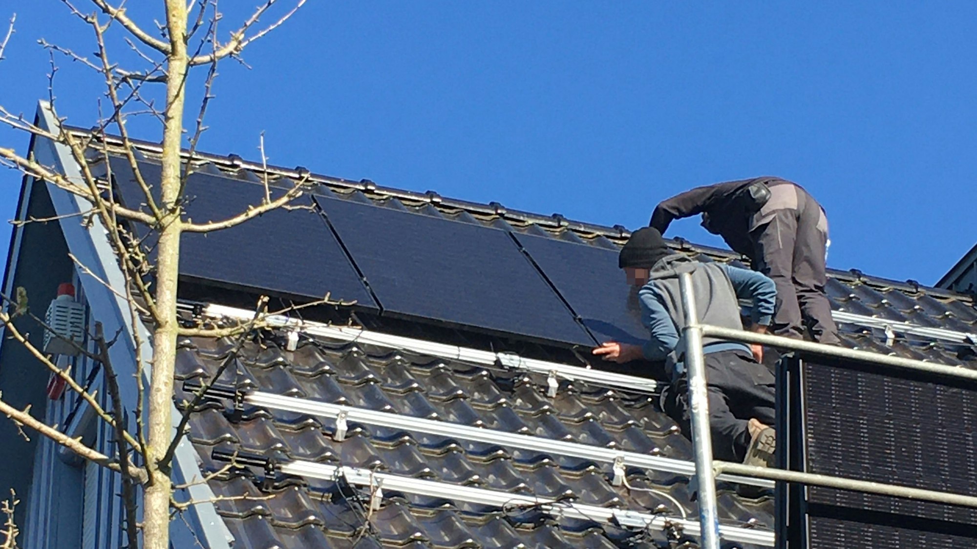Die Männer befestigen ein Photovoltaik-Modul auf der Unterkonstruktion.