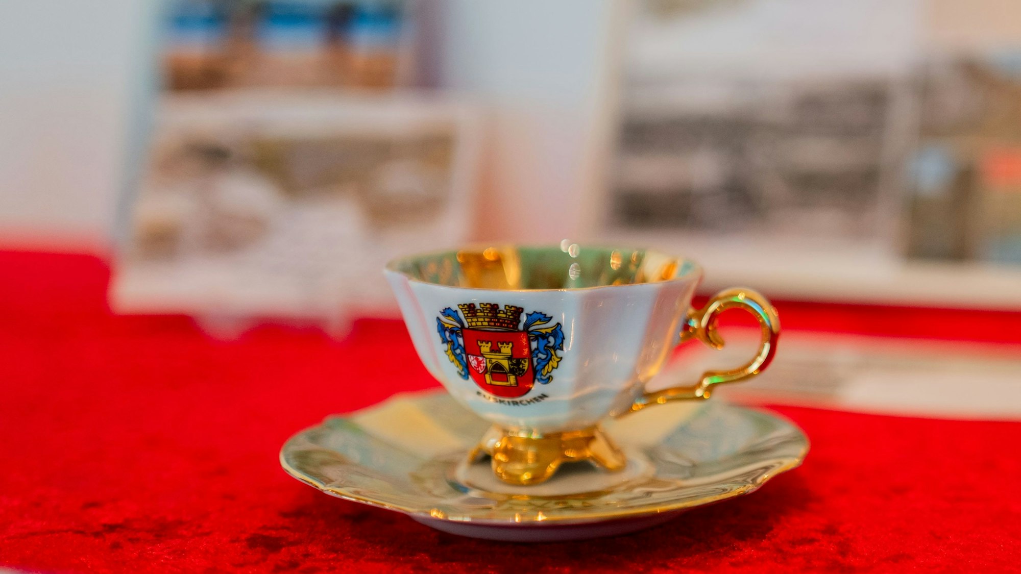 Das Bild zeigt eine Tasse mit goldenem Griff. Sie ziert das Stadtwappen von Euskirchen.