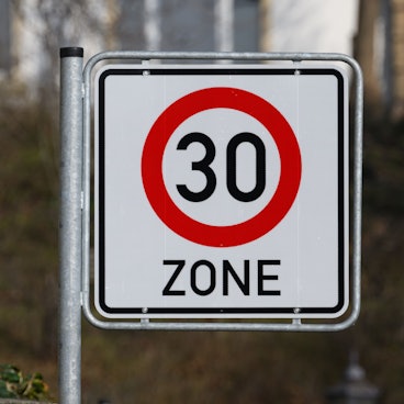 Ein Verkehrsschild Zulässige Höchstgeschwindigkeit 30 km/h steht an einer Straße.