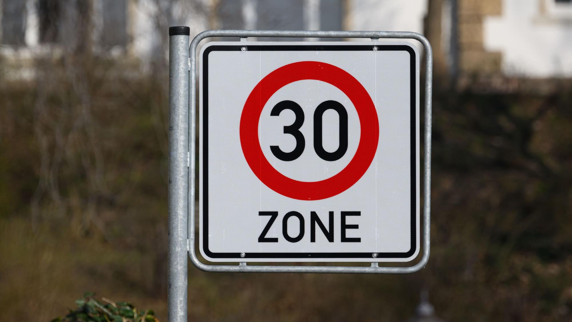 Ein Verkehrsschild Zulässige Höchstgeschwindigkeit 30 km/h steht an einer Straße.