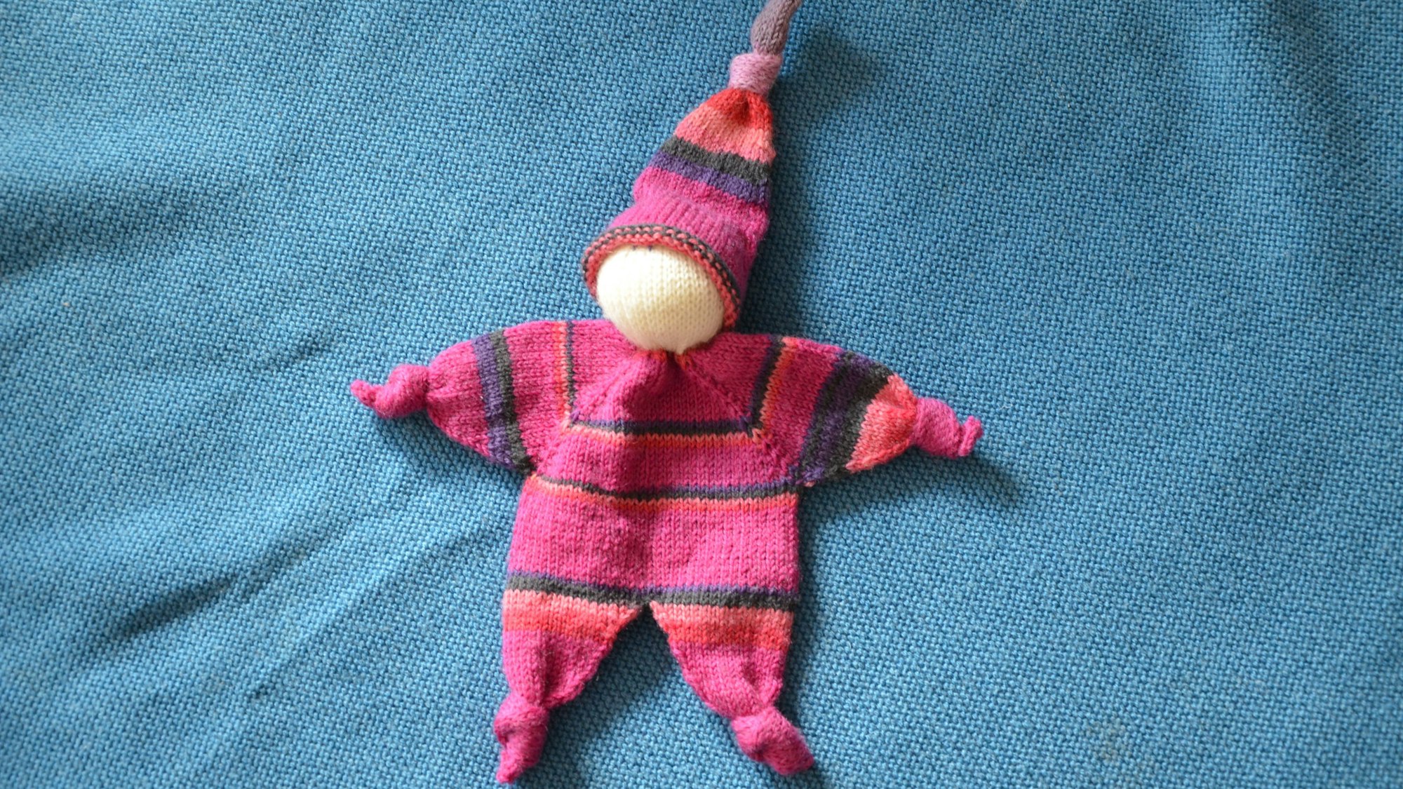 Das Foto zeigt ein genähtes Wollmännchen.