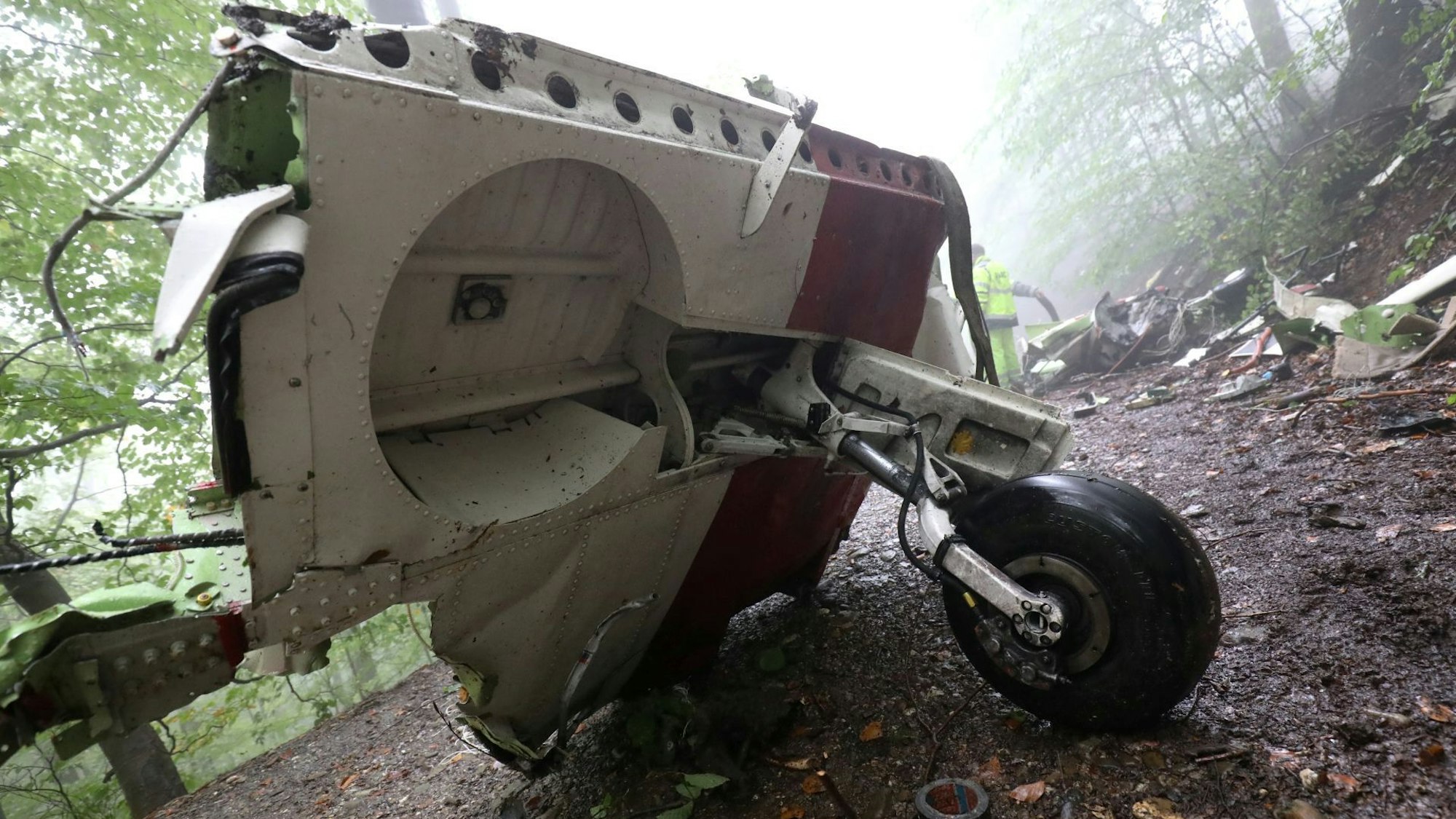 Teile des Fahrwerks eines Flugzeugs liegen auf einem Waldweg.