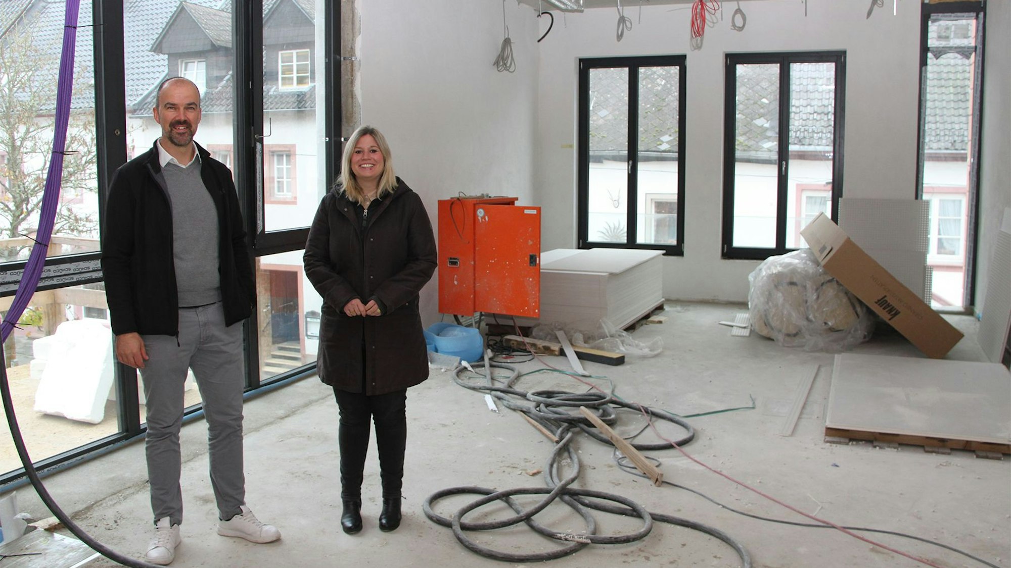 Bürgermeisterin Jennifer Meuren und Abteilungsleiter Guido Waters stehen in den einem Raum, der noch eine Baustelle ist.