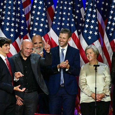 CEO of Ultimate Fighting Championship Dana White (C) gestures former US President and Republican presidential candidate Donald Trump acknowledges him during an election night event at the West Palm Beach Convention Center in West Palm Beach, Florida, on November 6, 2024. Republican former president Donald Trump closed in on a new term in the White House early November 6, 2024, just needing a handful of electoral votes to defeat Democratic Vice President Kamala Harris. (Photo by Jim WATSON / AFP)