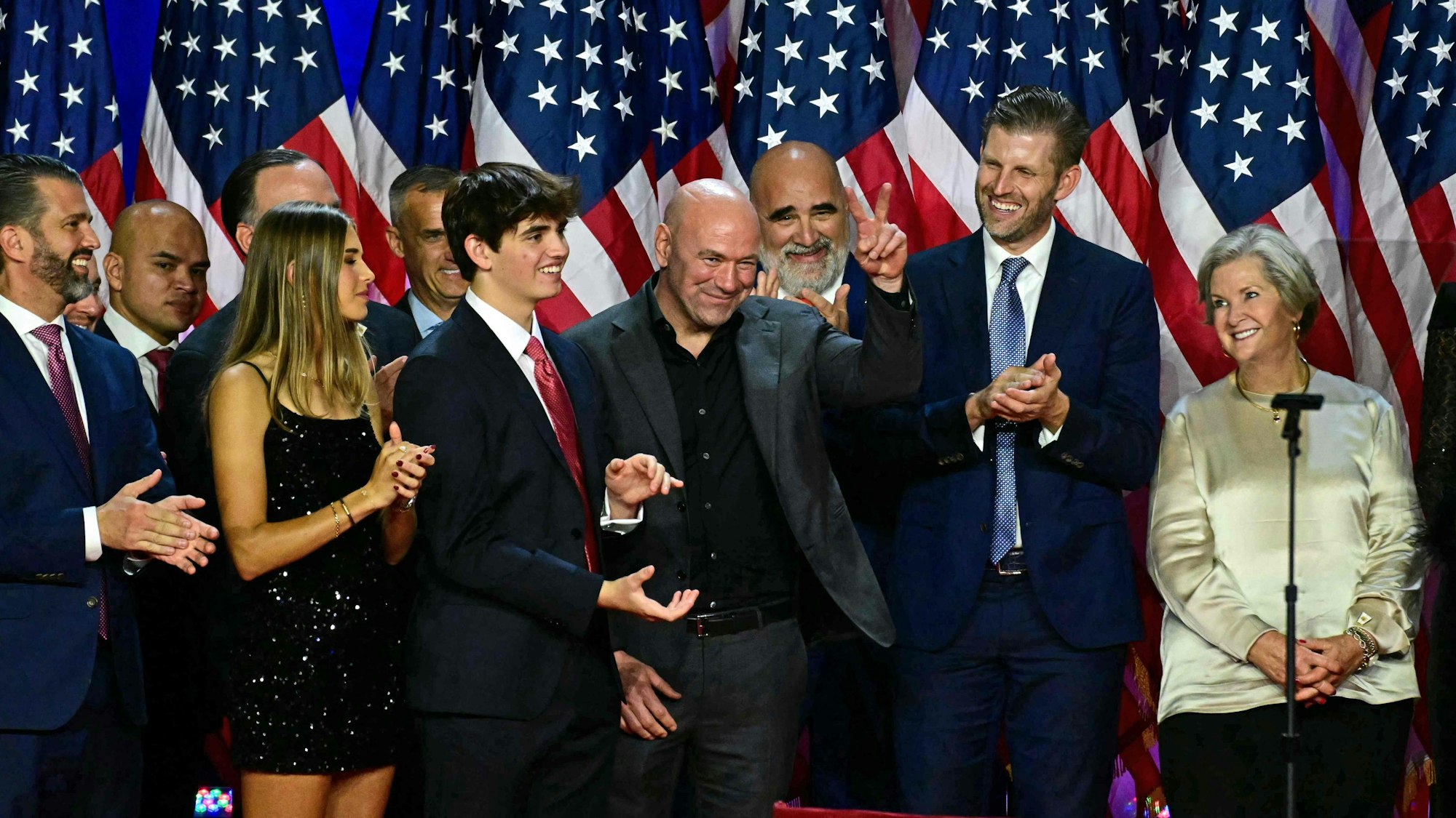 CEO of Ultimate Fighting Championship Dana White (C) gestures former US President and Republican presidential candidate Donald Trump acknowledges him during an election night event at the West Palm Beach Convention Center in West Palm Beach, Florida, on November 6, 2024. Republican former president Donald Trump closed in on a new term in the White House early November 6, 2024, just needing a handful of electoral votes to defeat Democratic Vice President Kamala Harris. (Photo by Jim WATSON / AFP)